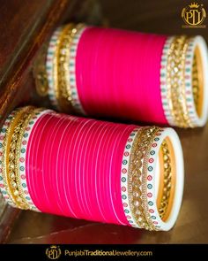 pink and gold bangles are stacked on top of each other