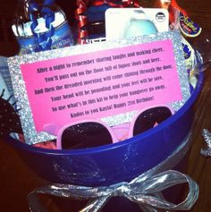 a birthday gift basket with sunglasses, candy and other personal care items in it on a table