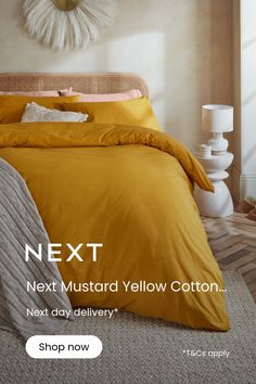 a bed with yellow comforter and pillows next to a wall clock that says next mustardd yellow cotton