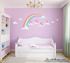 a child's bedroom with a rainbow wall decal on the wall and white furniture