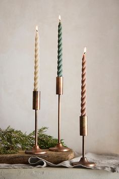 three candles sitting on top of a wooden table