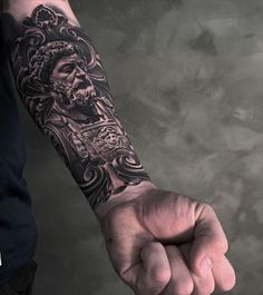 a man with a tattoo on his arm holding the fist of another person's hand