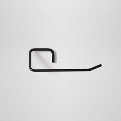 a black metal hook on a white wall