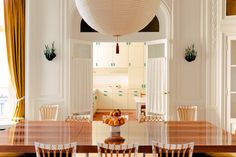 a dining room table with chairs and fruit on it