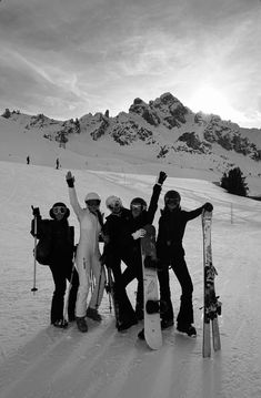 four snowboarders pose for a photo on the slopes