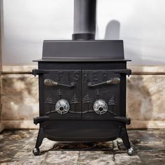 an old fashioned black stove sitting on top of a tiled floor