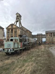 an old train sits abandoned in front of some buildings