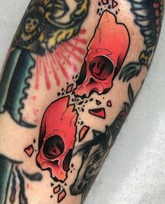 a close up of a person's leg with tattoos on it and two skulls in the background