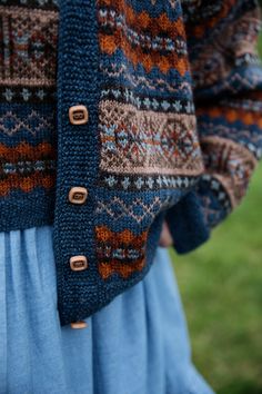 a close up of a person wearing a sweater with buttons on the front and back