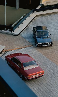 two cars parked next to each other in front of a building