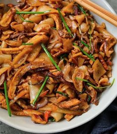 a white bowl filled with food and chopsticks