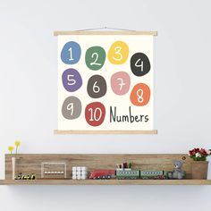 a wooden shelf topped with toys next to a wall mounted sign that reads 1, 2, 3, 4, 5, 6, and 9 numbers