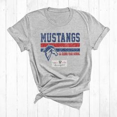 a gray shirt with the words mustangs in red, white and blue on it