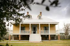 a yellow house with porches and stairs