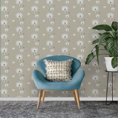 a blue chair sitting in front of a wall with a plant on top of it