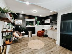 a living room filled with furniture next to a kitchen and dining room table in front of a black wall