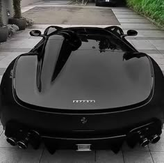 a black sports car is parked on the sidewalk