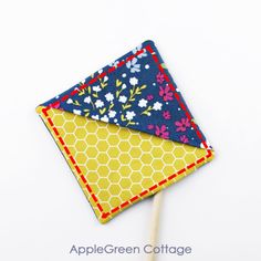 an apple green cottage lollipop stick holder is made from fabric and has a flower design on it