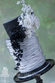 a white and black wedding cake with flowers on top