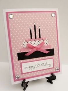 a pink and black birthday card with polka dots on the bottom, two candles in the middle