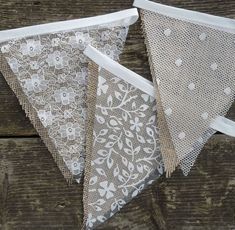 three white lace buntings are hanging on a wooden surface