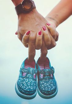 two people holding hands and wearing blue shoes with hearts painted on the toenails