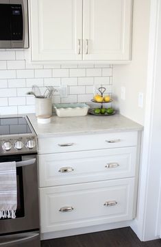 a kitchen with white cabinets and stainless steel appliances