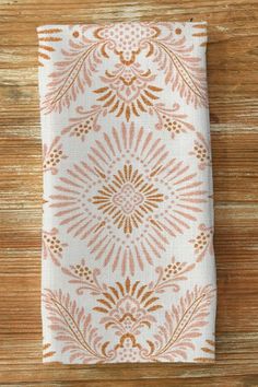 an orange and white napkin sitting on top of a wooden table