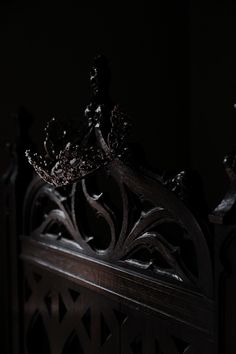 a metal headboard with a crown sitting on top of it in the dark room