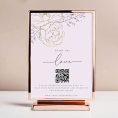 a white and gold wedding stationery with roses on the front, black text reads share the love