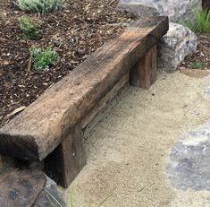 a wooden bench sitting next to some rocks