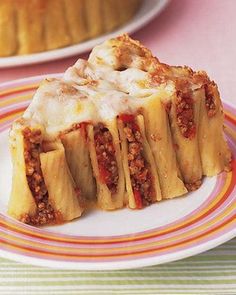 a piece of lasagna sitting on top of a plate next to a muffin