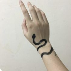 a hand with a black snake tattoo on it