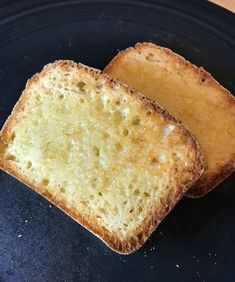 two pieces of bread sitting on top of a black plate