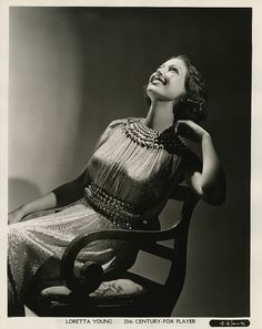 a black and white photo of a woman sitting on a chair