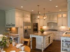 a large kitchen with white cabinets and marble counter tops, along with an island in the middle