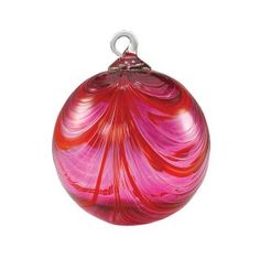 a red glass ornament sitting on top of a white table