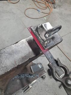 a piece of metal is being worked on with a pair of pliers in front of it