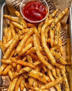 french fries with ketchup on the side in a metal tray, ready to be eaten