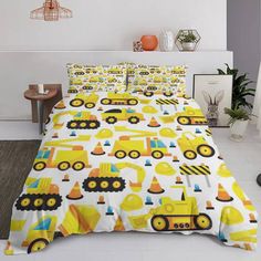 a bed with yellow construction themed sheets and pillow cases on top of it in a room