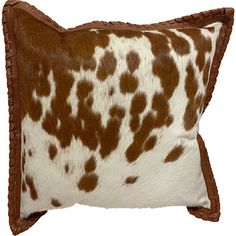 a brown and white cow print pillow on a white background