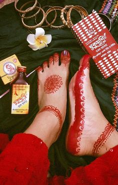 two feet with henna on them laying next to other items