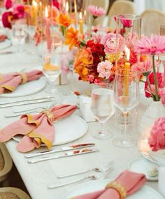 the table is set with pink and orange flowers