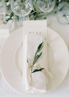 an image of a table setting with place cards and napkins on the plate, as well as wine glasses