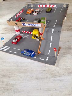 a toy car garage with cars on the road