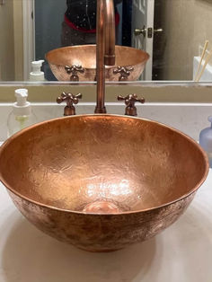 a large metal bowl sink sitting on top of a bathroom counter next to a mirror