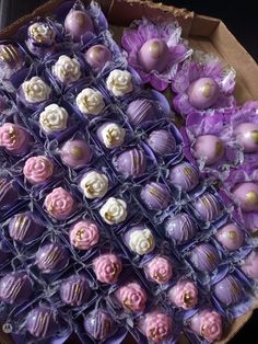 purple and white chocolates are arranged in boxes