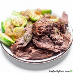 a plate full of meat and vegetables on a white tablecloth with text overlay