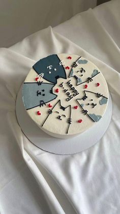 a cake decorated with cats and snowflakes on top of a white table cloth