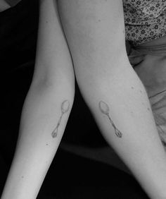 two people with tattoos on their legs holding tennis racquets in each other's hands